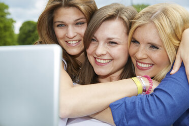 Drei lächelnde Freunde nehmen Selfie mit Tablet - FMKF002709