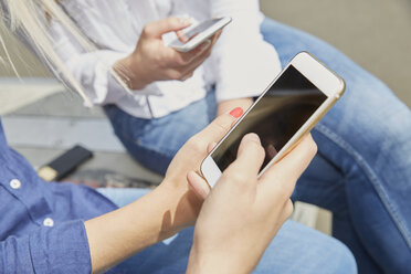 Hand of woman with smartphone, close-up - FMKF002710