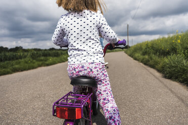 Girl on bicycle on country lane - UUF007395