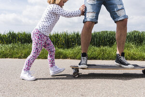 Tochter schiebt Vater auf Skateboard - UUF007397