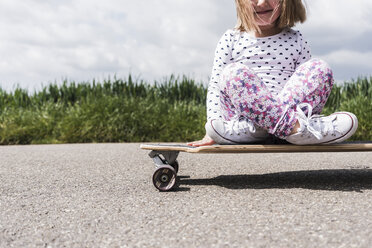 Mädchen auf Skateboard auf Feldweg - UUF007398