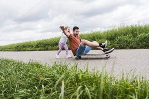Tochter schiebt Vater auf Skateboard - UUF007407