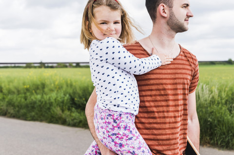 Vater hält Tochter im Freien, lizenzfreies Stockfoto