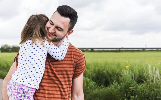 Tochter umarmt Vater im Freien - UUF007412