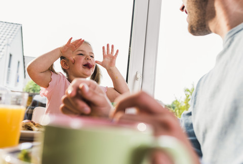 Mädchen streckt dem Vater die Zunge raus, lizenzfreies Stockfoto