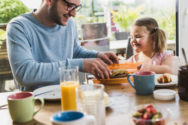 Father and daughter having breakfast together - UUF007438