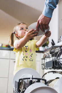 Tochter hilft Vater beim Ausräumen der Spülmaschine - UUF007446
