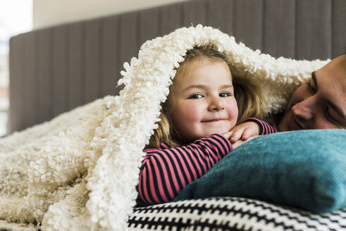 Father and daughter cuddling at home - UUF007458