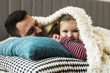 Father and daughter cuddling at home - UUF007459