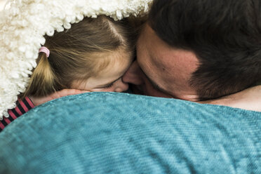 Father and daughter cuddling at home - UUF007460