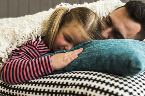 Vater und Tochter schlafen auf einem Kissen, lizenzfreies Stockfoto