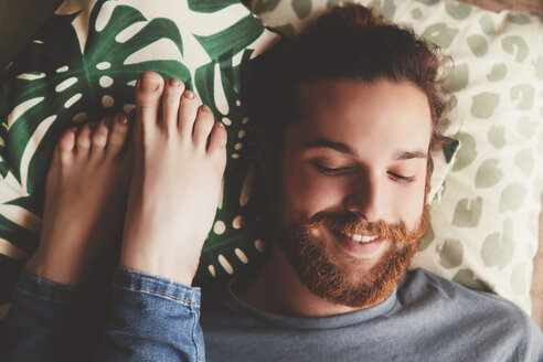 Portrait of smiling young man lying besides feet of his girlfriend - RTBF000224