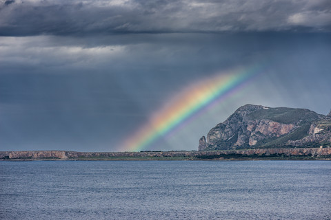 Italien, Sizilien, Provinz Trapani, Kletterfelsen Monte Monaco, Gewitterstimmung und Regenbogen, lizenzfreies Stockfoto