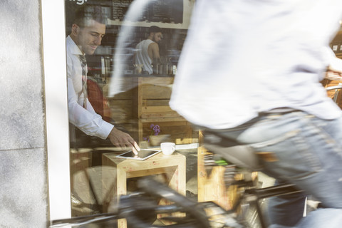 Geschäftsmann benutzt digitales Tablet in einem Café, lizenzfreies Stockfoto