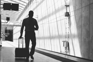Silhouette of businessman with luggage and cell phone on the move - MADF000887