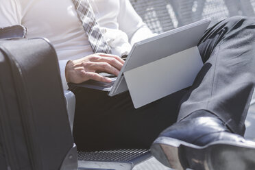 Businessman using digital tablet at waiting area - MADF000894