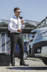 Businessman at car park opening car - MADF000942