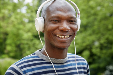 Portrait of smiling man with headphones - FMKF002734