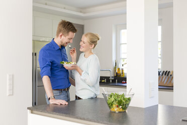 Happy couple in kitchen with salad - SHKF000607