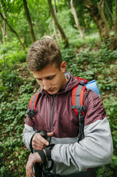 Serbien, Rakovac, junger Wanderer mit Blick auf eine Smartwatch - ZEDF000166