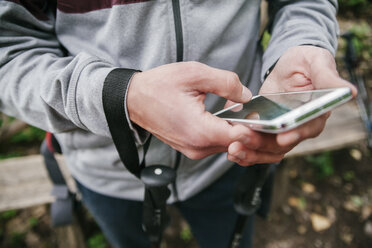 Serbien, Rakovac, junger Mann mit Smartphone beim Wandern - ZEDF000181