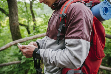 Serbien, Rakovac, junger Mann mit Smartphone beim Wandern - ZEDF000182