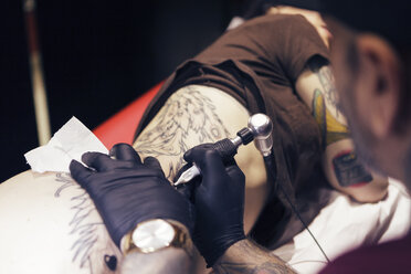 Tattoo artist tattooing a woman - XCF000091