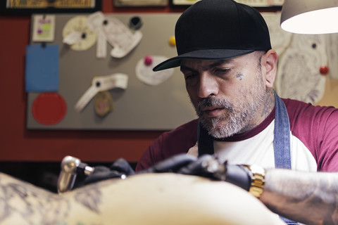 Tattoo artist tattooing a woman stock photo