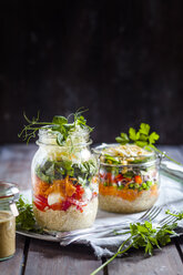 Rainbow salads in jars with quinoa, carrots, peas, red cabbage, bell pepper, mung bean sprouts, the other with tomatoes, mozzarella, spinach, pea sprouts - SBDF002917