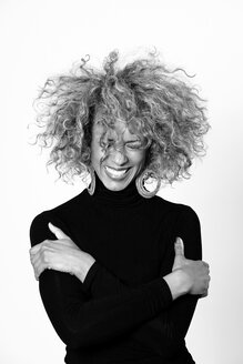 Portrait of laughing woman with afro wearing black turtleneck pullover - JCF000004