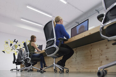 Employees working at computers in office - RHF001492