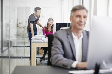 Älterer Geschäftsmann und Mitarbeiter bei der Arbeit im Büro - RHF001495