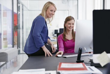 Two women working at computer in office - RHF001513