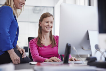 Two women working at computer in office - RHF001514