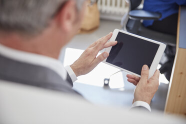 Mature man using digital tablet in office - RHF001525