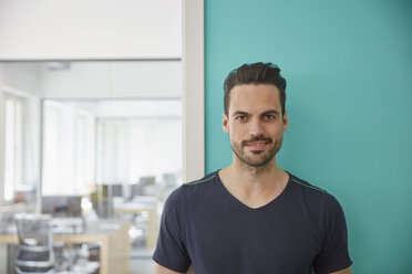 Man standing in office, portrait - RHF001532