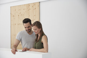 Two people in office looking at smart phone - RHF001563