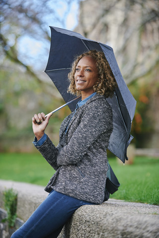 Porträt einer lächelnden Frau mit Regenschirm, lizenzfreies Stockfoto