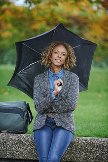 Portrait of smiling woman with umbrella - JCF000023