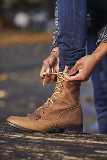Hands of woman tying boot - JCF000029