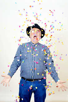 Portrait of senior man watching falling confetti - JCF000041