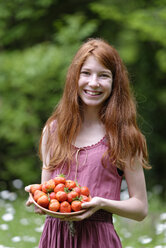 Porträt eines rothaarigen Teenagers mit einer Schale Erdbeeren - LBF001425