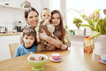 Portrait of happy mother with her three little children in the kitchen - MFF002971