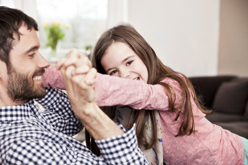 Tochter kämpft mit ihrem Vater auf der Couch - MFF002978