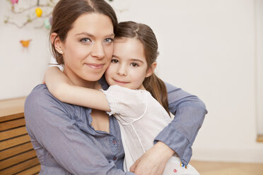 Portrait of mother and daughter hugging each other at home - MFF002984