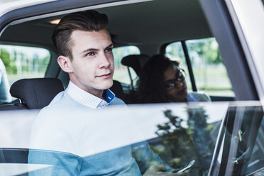Young man with cell phone and woman in car - UUF007481