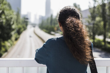 Junge Frau auf Brücke mit Blick auf die Straße - UUF007489