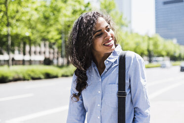 Smiling young woman in the city - UUF007536