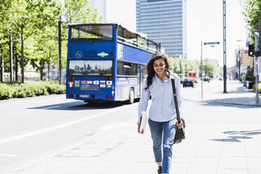 Smiling young woman on the move in the city - UUF007537