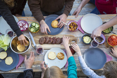 Family eating burgers at beer table - SARF002727